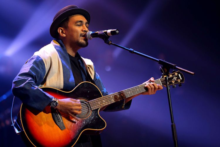 Selalu dengan topi bulat khasnya, Glenn Fredly beraksi di atas panggung dengan membawa gitar